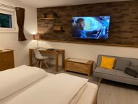 Haus Langweid - Ferienwohnung Aurelia Schlafzimmer abends mit Schreibtisch und Fernseher